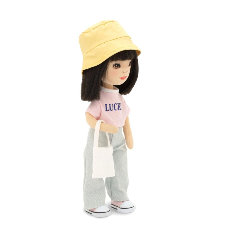Lalka Sweet Sisters Lilu 32 cm Orange Toys, szmaciana z endoszkieletem, twarz nadrukowana cyfrowo, czarne włosy, żółty kapelusz, różowa koszulka z napisem Lucky, jasnoszare jeansy, buciki, torebka