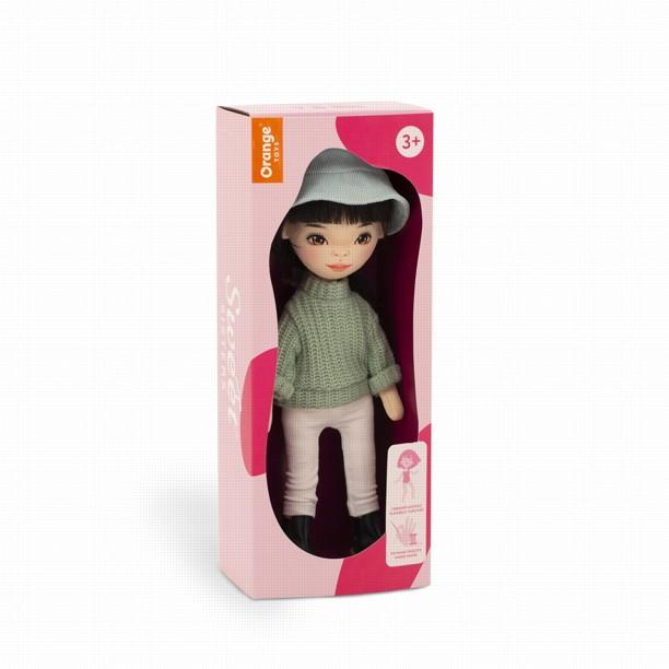 Lalka Sweet Sisters Lilu 32 cm Orange Toys, szmaciana z endoszkieletem, twarz nadrukowana cyfrowo, czarne włosy, jasnoturkusowy kapelusz, zielony sweterek, białe legginsy, buciki, torebka