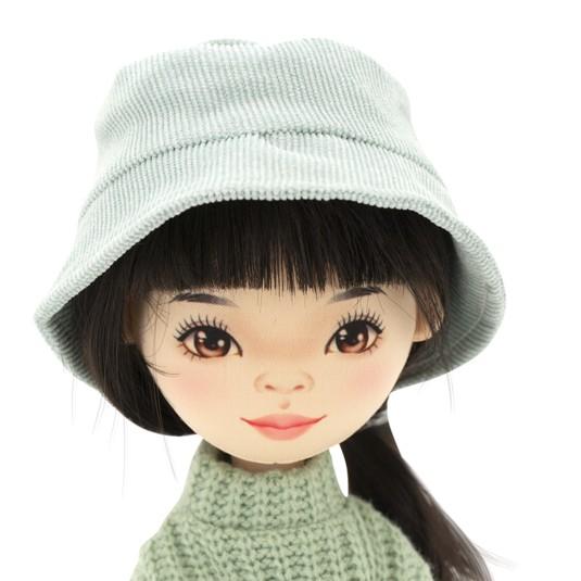Lalka Sweet Sisters Lilu 32 cm Orange Toys, szmaciana z endoszkieletem, twarz nadrukowana cyfrowo, czarne włosy, jasnoturkusowy kapelusz, zielony sweterek, białe legginsy, buciki, torebka