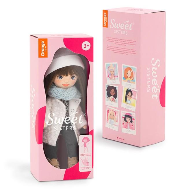 Lalka Sweet Sisters Sophie 32 cm Orange Toys, szmaciana z endoszkieletem, twarz nadrukowana cyfrowo, ciemnobrązowe włosy, czapeczka, niebieski szalik, biały puszysty płaszczyk, bluzeczka, czarne jeansy, buciki