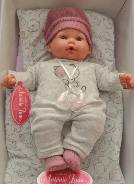 Lalka Hiszpańska 27 cm Antonio Juan 11115 Kika, bobas miękki brzuszek, płacze, mówi mama papa, bez włosów, w ubranku, magnetyczny smoczek, kołderka i poduszka